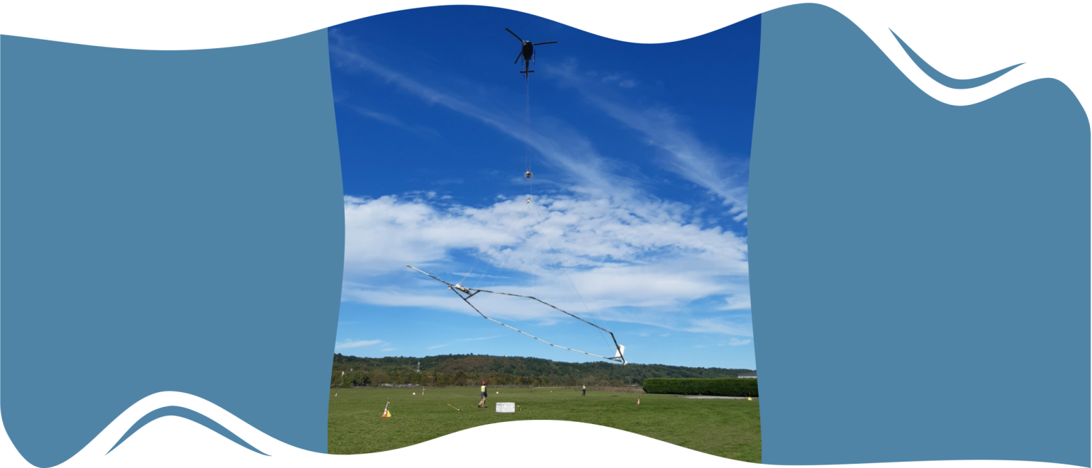 Hélicoptère en vol tractant une antenne hexagonale permettant de faire des relevés géophysiques (source : BRGM)